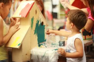 girl in white tank top holding blue and white paint brush
